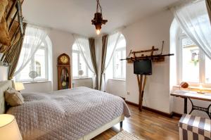 um quarto com uma cama, um relógio e janelas em Ferienwohnung LANDHAUSSUITE Annaberg-Buchholz em Annaberg-Buchholz