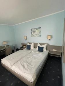 ein Schlafzimmer mit einem großen weißen Bett mit blauen Wänden in der Unterkunft Hotel Borger in Frankfurt am Main