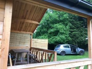 a cabin with a table and a car parked in the grass at Chatka pod orzechem in Spytkowice