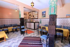 ein Restaurant mit Tischen und Stühlen in einem Raum in der Unterkunft Hotel Igoudar Armed in Imlil