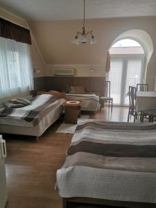 ein Schlafzimmer mit 2 Betten und ein Wohnzimmer in der Unterkunft Molnár Apartment in Sárvár