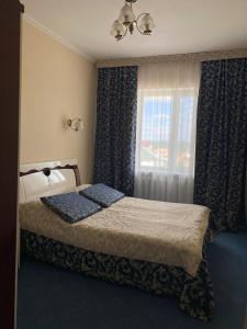 sypialnia z łóżkiem i oknem w obiekcie Отель Ак Булак w mieście Borowoje