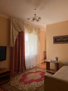 - un salon avec un canapé et une fenêtre dans l'établissement Отель Ак Булак, à Borovoe