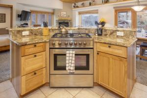 uma cozinha com um fogão de aço inoxidável e armários de madeira em Clover at Slopeside Village townhouse em Winter Park