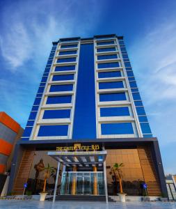 a tall building with a sign in front of it at The Gate Hotel and Apartments in Dammam