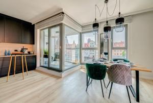 The Black Crane Apartment في غدانسك: مطبخ وغرفة طعام مع طاولة وكراسي