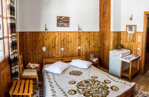 ein Schlafzimmer mit einem Bett in einem Zimmer mit Holzwänden in der Unterkunft Filoxeni Gonia in Metsovo