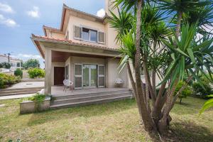 una casa con un porche con una palmera en Casa Branco en Viana do Castelo