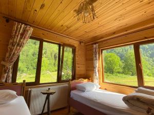 a bedroom with two beds and a large window at Çamdibi Konaklama in Rize