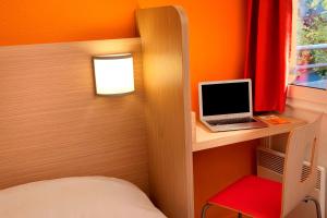 sypialnia z łóżkiem i laptopem na biurku w obiekcie Premiere Classe Reims Sud - Bezannes w mieście Reims