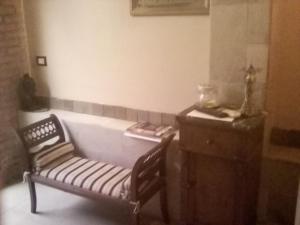 una stanza con panchina, comò e tavolo di Guest house La Corte Normanna a Sciacca