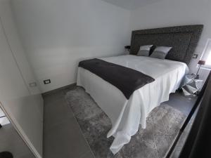 a bedroom with a white bed with a black blanket at Palms Luxury Suites Sanremo in Sanremo