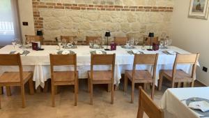 a dining room with a white table and chairs at Tenuta Micoli in Frisa