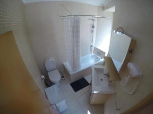 a bathroom with a shower and a toilet and a sink at Studios by Blue Door in Portimão