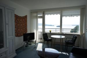 a living room with a table and chairs and a television at Seeperle in Malente