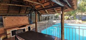 an outdoor swimming pool with a pavilion and a swimming pool at Lytton Cresent B&B in Pinetown