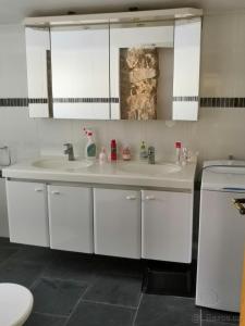 a white bathroom with two sinks and a toilet at Roubenka Krkonoše - Adršpach in Radvanice