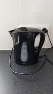 a black coffee pot with a cord plugged into it at Ruim en gezellig chalet voor 2 personen op de Veluwe Recreatiepark De Oude Driest - All inclusive in Putten