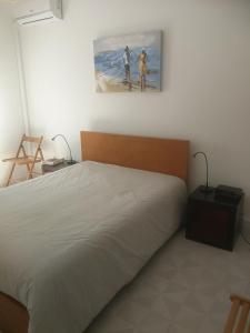 um quarto com uma cama e uma pintura na parede em Casa do Algarve em Albufeira