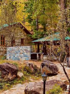 a stone house with a street light in front of it at Tirthan Anglers' Retreat in Banjār