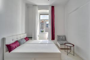 a white couch in a room with a window at Collins Amethyst Center in Pula