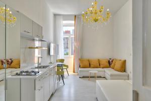 a white kitchen and living room with a chandelier at Collins Amethyst Center in Pula