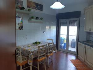 cocina con mesa con sillas y mesa en Casa di Roberta, en Santa Teresa di Riva