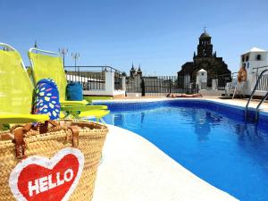 una piscina con due sedie a sdraio e un cartello a forma di cuore accanto di Sherryflat Jarana- Parking a Jerez de la Frontera