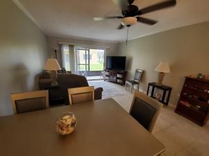 uma sala de estar com uma mesa com cadeiras e um sofá em Pelican Inlet C117 condo em Saint Augustine