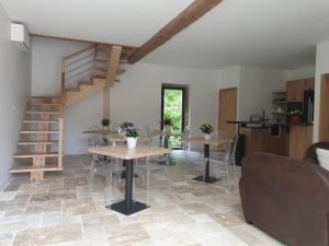 a living room with a staircase and tables and chairs at LE CARGE D’ARLAY in Charnay-lès-Mâcon