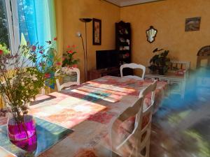 un comedor con una mesa con flores y un mantel en la petite maison bleue, en Jugon Les Lacs