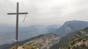 una cruz en la cima de una montaña con vistas en Apartments Giovannini en Fai della Paganella