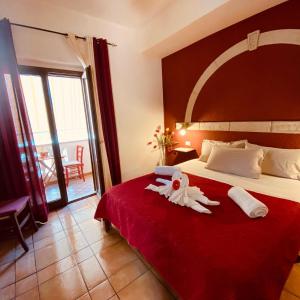 ein Hotelzimmer mit einem Bett mit ausgestopftem Tier darauf in der Unterkunft Rosa dei Venti Accomodation in Tropea