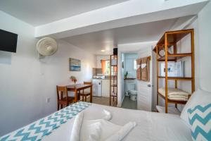 ein Schlafzimmer mit Bett und eine Küche mit Schreibtisch in der Unterkunft Placencia Villas in Placencia Village