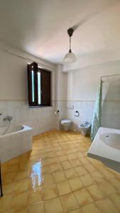 a bathroom with two sinks and a tub and a toilet at Monolocale & Suite Casa Santicelli Maratea in Maratea +2 photos