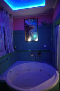 eine große weiße Badewanne in einem Zimmer mit einem Gemälde in der Unterkunft Passion Fruit Apartment in Aschkelon