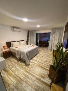 - une chambre avec un lit et une table dans l'établissement CHOUPANA SUÍTES, à Japaratinga