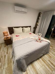 um quarto com uma cama com um urso de peluche em CHOUPANA SUÍTES em Japaratinga