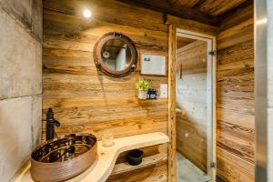 een houten badkamer met een wastafel en een spiegel bij Chalet ''la cabane ô Pierres'' 12 pers spa et sauna in Ventron