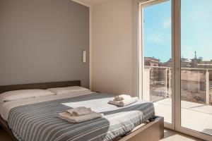 sypialnia z łóżkiem i dużym oknem w obiekcie Residence Sunrise w Cesenatico