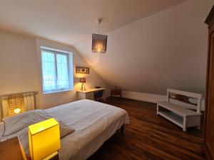 a bedroom with a bed and a table and a window at Maison tout confort avec jardin - CHANTILLY, SENLIS, PARC ASTERIX, PARIS CDG in Avilly-Saint-Léonard