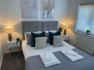 a bedroom with a large bed with green and white pillows at Sutton Heath Lodge in Saint Helens +14 photos