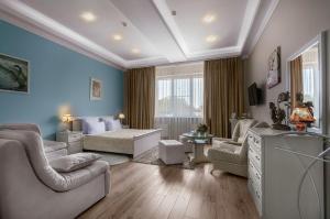 uma sala de estar com paredes azuis e mobiliário branco em Tesoro Hotel em Rostov on Don
