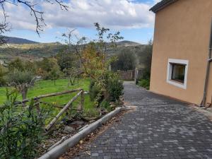 een bakstenen loopbrug naast een gebouw met een raam bij Green Deluxe Apartment “La locanda del Borgo” in San Donato di Ninea