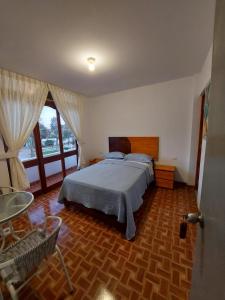 1 dormitorio con cama y ventana grande en El Capricho Paracas en Paracas