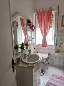 un baño con lavabo y espejo en Casa da Tina Conforto Familiar no Sítio da Nazaré, en Nazaré