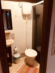 a bathroom with a toilet and a sink at Casinha Astral - Praia da Ferrugem in Garopaba