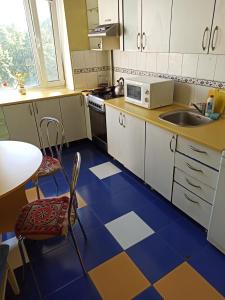 a kitchen with a blue and white tiled floor at 3-х комнатная квартира in Okhtyrka