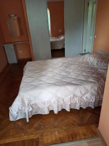 a bedroom with a large bed with a white comforter at 3-х комнатная квартира in Okhtyrka