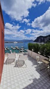 eine Terrasse mit Stühlen und Blick auf das Wasser in der Unterkunft Capri Marina Suite in Capri